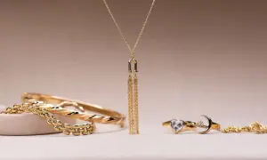 Elegantes conjuntos de oro para mujer: brazaletes, un collar con flecos dorados y anillos con forma de corazón y luna.