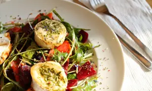 Ein köstlicher Rote Bete Salat mit Ziegenkäse, garniert mit Kräutern und Blüten.