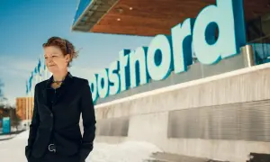 Annemarie Gardshol står framför Postnords logotyp en solig vinterdag.