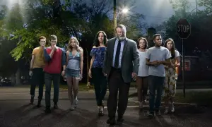 En grupp människor, inklusive rollistan i Mr. Mercedes, går mot kameran på en mörk gata under en gatlykta.