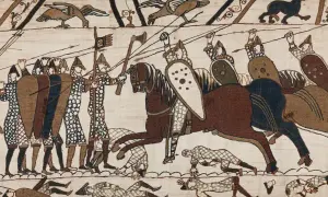 Scen från slaget vid Hastings 1066. Soldater med sköldar och spjut, en ryttare på häst. Nedanför fallna krigare.