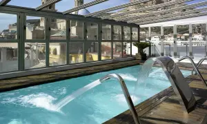 Piscina con cascadas y vistas a la ciudad, ideal para un spa bodyna Valencia.