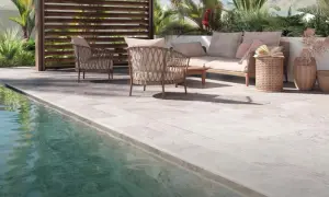 Terraza junto a piscina con mobiliario de exterior. El suelo antideslizante es el mejor suelo para exterior, seguro y elegante.