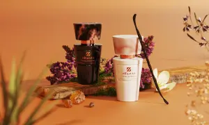 Dwa eleganckie flakony perfum Olfazeta, czarny i biały, otoczone kwiatami i laską wanilii. Idealne kosmetyki w bagażu rejestrowanym na podróż.