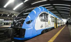 Niebiesko-biały pociąg PKP na peronie. Zastanawiasz się, jak zwrócić bilet PKP kupiony przez internet bez rejestracji? Sprawdź procedury online.