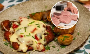 Pyszny kotlet po zbójnicku, zapieczony z serem i warzywami, podany z pieczonymi ziemniakami. W rogu widać surowe mięso do kotleta.