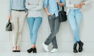 Cztery osoby w stonowanych kolorach, prezentujące styl normcore. Jasne jeansy, beżowe spodnie i szare dżinsy tworzą bazę dla prostych, wygodnych stylizacji.
