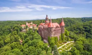 Majestätisches Schloss Kynast, eingebettet in grüne Wälder in Niederschlesien, mit roten Dächern und gepflegten Gärten.