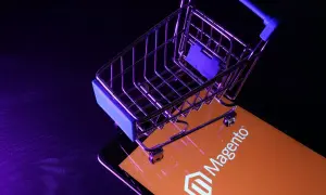 Miniaturowy wózek na zakupy na ekranie z logo Magento, symbolizującym potęgę ecommerce.