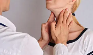 Lekarz bada szyję pacjentki, palpacyjnie oceniając węzły chłonne. Zdjęcia pokazują, jak wyglądają powiększone węzły chłonne.
