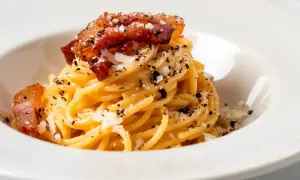 Pyszne spaghetti carbonara z chrupiącym, włoskim boczkiem do carbonary, posypane parmezanem i pieprzem.