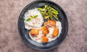 Saftige Lachsfilets in cremiger Sahnesauce, serviert mit Reis und grünem Spargel. Ein köstliches Gericht, das Lust auf mehr macht.