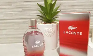 Perfumy męskie Lacoste Red 125ml w szklanej butelce obok czerwonego kartonika.