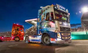 Deux camions décorés, dont un aux couleurs de Spiderman, défilent sur la piste du Mans devant une foule en délire.