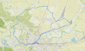 Trasa rowerowa, zaznaczona niebieskim velo, okrąża miasto Przemyśl, prowadząc przez malownicze tereny i wsie.