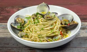 Spaghetti alle vongole, un piatto gustoso con vongole fresche e prezzemolo, pronto per essere gustato.