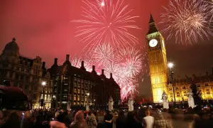 Fuegos artificiales iluminan el cielo sobre el Big Ben y el Parlamento, celebrando las festividades inglesas con una multitud expectante.