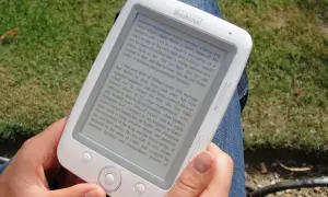 Osoba czyta książkę na czytniku Bookeen. Ta aplikacja do czytania książek pozwala zabrać ze sobą całą bibliotekę.