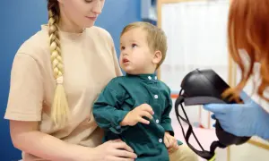 Matka z synkiem u lekarza. Dziecko patrzy z zaciekawieniem na sprzęt medyczny, a rodzicielka z troską. Czy epilepsja jest uleczalna?