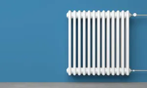 Radiatore bianco su muro blu. Un termotecnico cosa fa? Si assicura che il calore sia distribuito in modo efficiente.