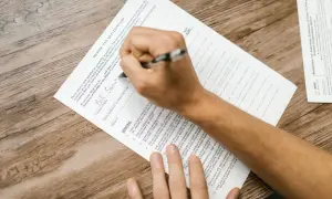Osoba wypełnia formularz podatkowy, przygotowując się do złożenia dokumentów związanych z umowami o unikaniu podwójnego opodatkowania.