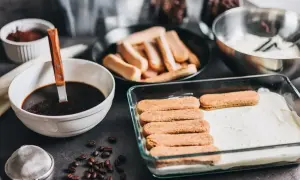 Przygotowanie tiramisu w ciąży: biszkopty maczane w kawie, krem i kakao. Pyszny deser dla przyszłej mamy.