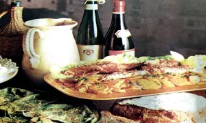 Un banchetto con pesce, verdure e pane fresco, accompagnato da vino e brocca. Sapori autentici del **chilometro zero Rodi Garganico**.