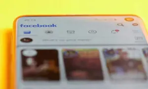 Telefon z otwartą aplikacją Facebook. Widoczny pasek wyszukiwania i ikony powiadomień. Dowiedz się, jak znaleźć swoje relacje na Facebooku.