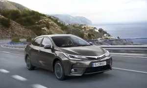 Brązowa Toyota Corolla 2017 jedzie krętą drogą nad morzem.