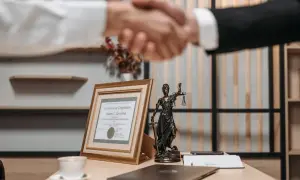 Uścisk dłoni prawników, certyfikat ukończenia i Statua Temidy. Dowiedz się, jak szybko się rozwieść, szukając profesjonalnej pomocy.