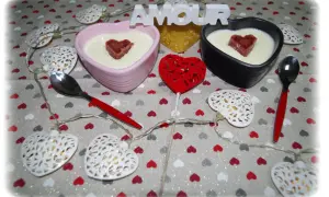Deux panna cotta au mascarpone, décorées de cœurs, sur une nappe à cœurs. Parfait pour une recette panna cotta mascarpone.