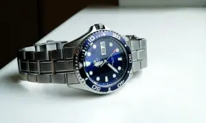 En blå dykarklocka, Orient Ray II, med ett silverfärgat armband ligger på en vit yta.