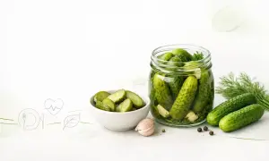 Słoik pełen ogórków kiszonych, miseczka pokrojonych, czosnek i koperek. Czy ogórki kiszone są zdrowe? Tak, to naturalny probiotyk!
