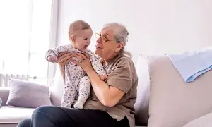Babcia tuli niemowlę w piżamce z autkami. Czas spędzony w babciowych warunkach to czysta radość.