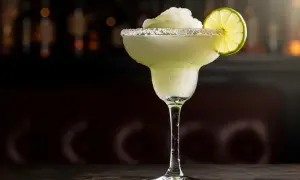 En frostig frozen margarita med saltkant och limeklyfta, perfekt för en varm kväll.