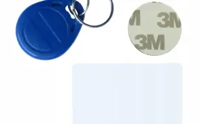 Niebieski brelok zbliżeniowy, krążek z logo 3M i biała karta. Zestaw do nauki, jak zakodować domofon.