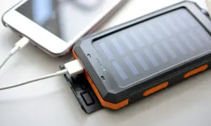Ładowanie słuchawek bezprzewodowych ładowarką do telefonu jest możliwe, jeśli mają ten sam typ złącza. Na zdjęciu widać powerbank z panelem słonecznym ładujący telefon.