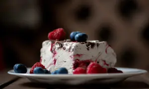 Ein Stück Eistorte mit Beeren und Schokostückchen, perfekt für ein einfaches Eistorte Rezept.