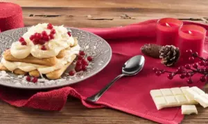 Un délicieux tiramisu chocolat blanc, garni de fruits rouges et de copeaux de chocolat, prêt à être dégusté.