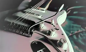 Biała gitara elektryczna, dzieło Leo Fendera, z widocznymi strunami, mostkiem i pokrętłami.