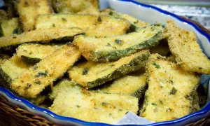 Fettine di zucchine impanate e dorate, pronte per essere gustate. Un contorno sfizioso e leggero, perfetto per ogni occasione.