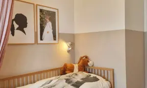 Sanftes **Kinderzimmer** mit Pferde-Bettwäsche, Plüschpferd und Bildern. Die Wände sind zweifarbig gestrichen.