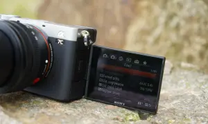 Aparat Sony a7c z obiektywem, na ekranie widoczne menu filmowania z ustawieniami XAVC S 4K.
