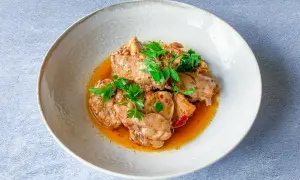 Sabroso conejo en salmorejo, trozos de carne tierna bañados en una salsa rica y aromática, decorado con perejil fresco.