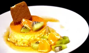 En krämig creme caramel med frukt och en kexbit. Perfekt för ett somrigt recept.