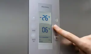Palec naciska przycisk "super" na panelu zamrażarki. Wyświetlacz pokazuje, jaka temperatura w zamrażarce to -26°C.