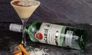 Koktajl z wiórkami kokosowymi i cynamonem, obok butelka Bacardi Carta Blanca. Idealny sposób, jak pić Bacardi!