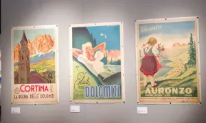 Tre manifesti vintage di una collezione salce promuovono le Dolomiti: Cortina, una donna rilassata e una bambina con fiori ad Auronzo.