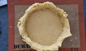 Pâte à gâteau basque prête à être garnie, posée sur un tapis Silpat.