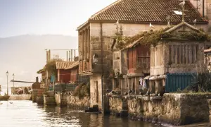 Casas de piedra y madera junto al agua, gaviotas en los tejados. Un ejemplo de los pueblos bonitos de Galicia.